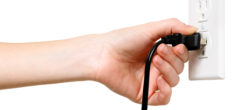 Photo of a person inserting a plug into an outlet, representing electricity demand